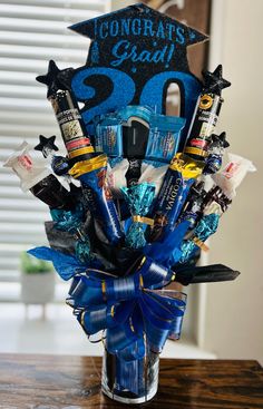 the graduation bouquet is decorated with blue ribbon and congratulationss for someone's grad