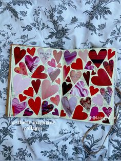 an open book with hearts cut out of it sitting on a bed covered in floral fabric