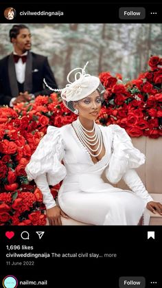 a woman sitting on top of a bench wearing a white dress and headpieces