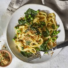 a white plate topped with pasta and peas