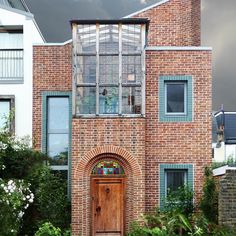 a brick building with a wooden door and arched glass window on the front entrance to it