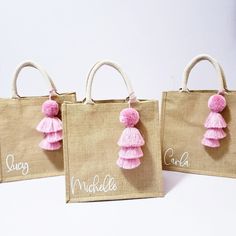 three bags with pink tassels and name on them