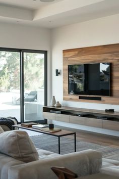 a living room filled with furniture and a large flat screen tv mounted on the wall