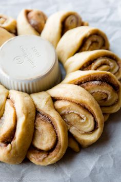 cinnamon buns are arranged in a spiral on top of wax paper with a bottle