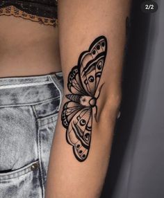 a woman's arm with a black and white butterfly tattoo on the left side