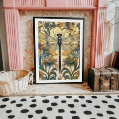 a painting sitting on top of a table next to a basket and suitcases in front of a fire place