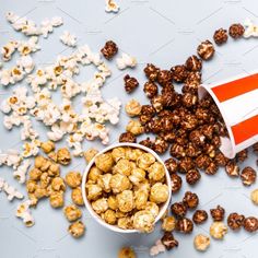 popcorn kernels spilling out of a paper cup on a blue background with white and red stripes