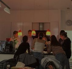 a group of people standing around in a kitchen