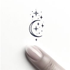 a person's finger with a drawing of a crescent and stars on the tip