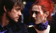 a man and woman with red hair are looking into each other's eyes at something