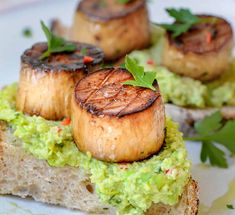 some kind of food that is on top of a white plate with green garnish