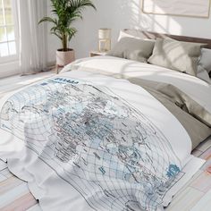 a bed with a white comforter and a map on the pillow cover in front of it