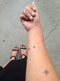 a woman's arm with stars on it and her left hand holding the wrist