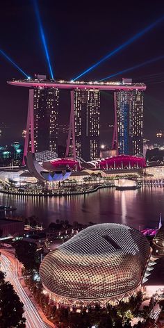 an aerial view of the marina bay area at night, with lights shining in the background