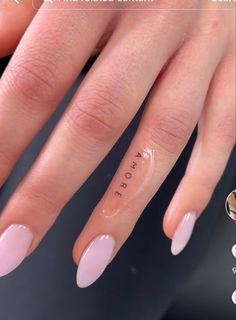 a woman's nails with the word hope written on it and an arrow tattoo