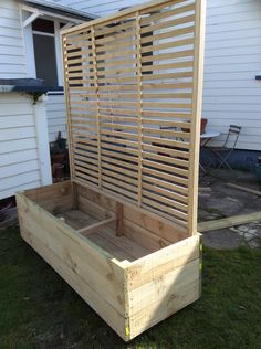 a wooden bed with slats on the top and bottom in front of a house