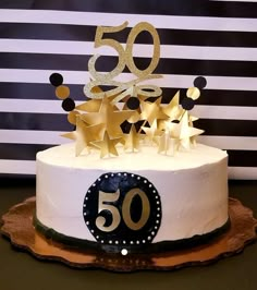 a 50th birthday cake decorated with gold stars and the number 50 on it's top