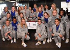 the women's soccer team is posing for a group photo in front of a table