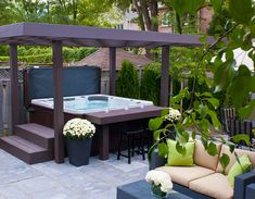 a hot tub sitting on top of a patio next to a table and couches