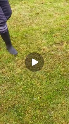 a person standing on top of a lush green field next to a frisbee