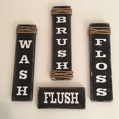 three wooden signs that say brush, wash, flush and have words written on them