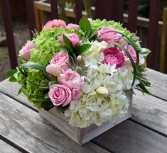 a wooden box filled with pink and white flowers