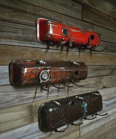 there are two red and one black wall mounted guitars on the wooden planked wall