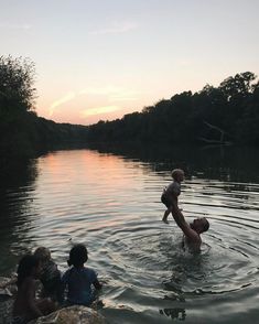 some people are playing in the water with a child on their shoulders and an adult standing up above them