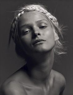 a black and white photo of a woman with braids on her head looking up