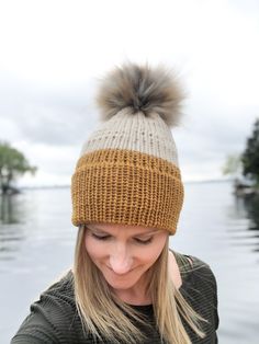 a woman wearing a knitted hat with a pom - pom on it