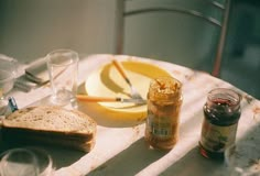 a table with bread, jam and butter on it