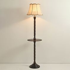 a lamp that is sitting on top of a table next to a white wall and floor