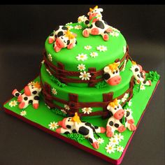 three tiered cake decorated with green frosting and farm animals on it's sides