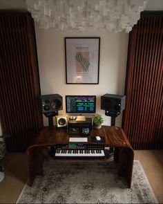 a desk with a keyboard, monitor and speakers