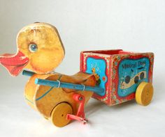 a wooden toy truck with a rubber ducky on it's front and side wheels