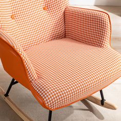 an orange and white chair sitting on top of a wooden floor