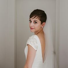 a woman in a wedding dress is looking at the camera