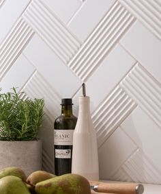 a bottle of wine sitting on top of a counter next to pears