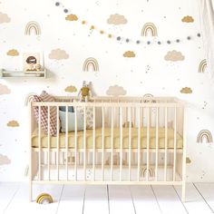 a baby's room with clouds and rainbows on the wall