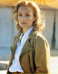 a woman in a brown jacket and white shirt