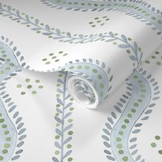 a wallpaper with blue and green leaves on it's side, next to a roll of white paper