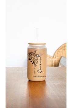 a mason jar with a straw in it sitting on a table