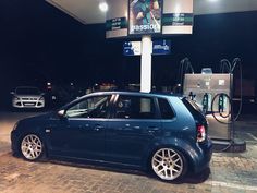 a blue car is parked in front of a gas station