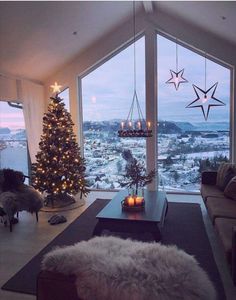 a living room filled with furniture and a christmas tree in front of a large window