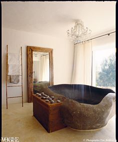 a large bathtub sitting in the middle of a room with a chandelier