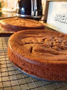 two cakes sitting on top of a metal rack