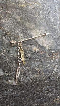 an arrow and feather charm on a rock