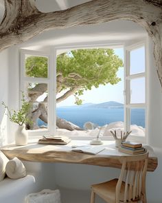 an open window with a view of the ocean and tree branches in front of it