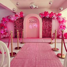 a pink and gold party setup with balloons