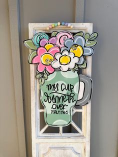 a sign with flowers in a vase on the front of a door that says, my cup is summer over